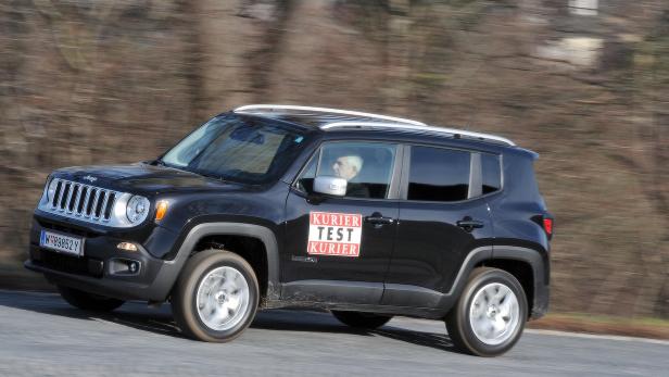 Ein schwarzer Jeep Renegade mit „Kurier Test Kurier“-Aufkleber fährt auf einer Straße.