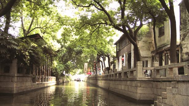 Ein Kanal schlängelt sich durch eine traditionelle chinesische Stadt.