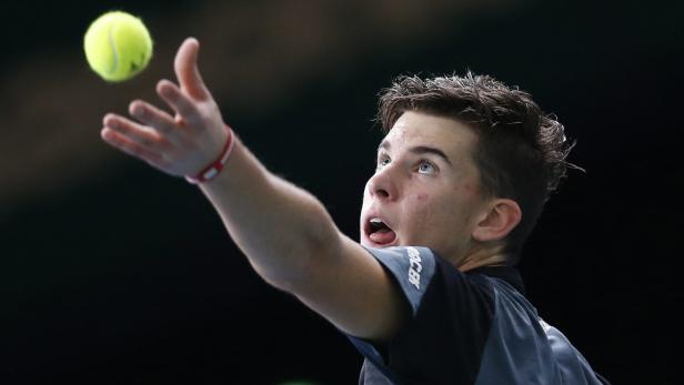 Ein Tennisspieler wirft einen Ball hoch, um aufzuschlagen.