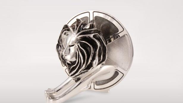 Eine silberne Löwenstatue vor einer Filmrolle.