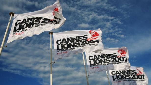 Mehrere „Cannes Lions 2007“-Flaggen wehen vor blauem Himmel.