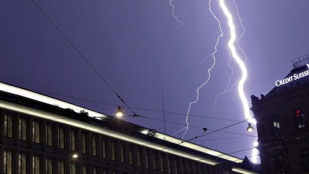 Lightning strike over the headquarters of Swiss banks UBS and Credit Suisse during a thunderstorm over the Paradeplatz square in Zurich in this August 24, 2011 file photo. Swiss banks hoping to atone for decades of complicity in tax evasion may be left to sweat it out for months as the United States and Germany ponder the right level of punishment. Switzerland has long dodged U.S. accusations of hiding money for wealthy Americans. But now eleven Swiss banks are under investigation in the United States and there is pressure too from Europe where burdened taxpayers want scalps after numerous banking scandals. The Swiss need a deal to remove the taint from their financial industry. REUTERS/Arnd Wiegmann/Files (SWITZERLAND - Tags: BUSINESS CITYSPACE ENVIRONMENT TPX IMAGES OF THE DAY)