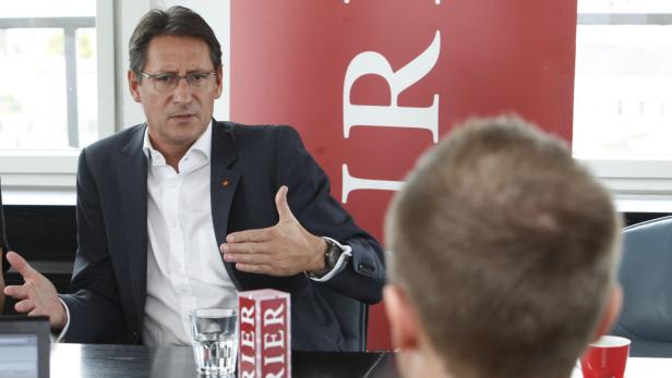 Ein Mann in Anzug gestikuliert während eines Gesprächs.