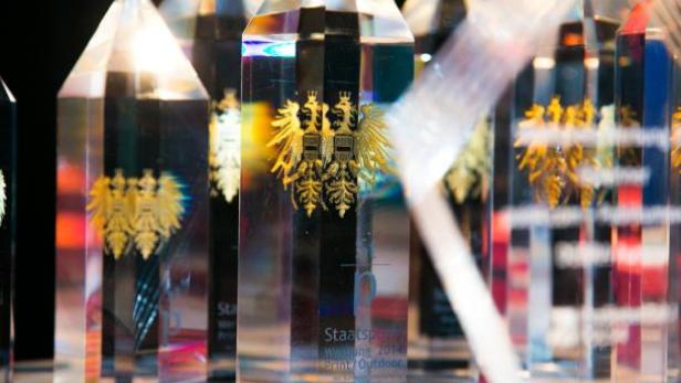 Mehrere Staatspreis-Trophäen aus transparentem Acryl mit goldenem Bundesadler.