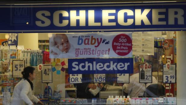 Ein Blick durch das Fenster eines Schlecker-Marktes mit Babyprodukten und Preisangeboten.
