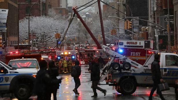 Einsatzfahrzeuge und Rettungskräfte in einer verschneiten Straße in New York City.