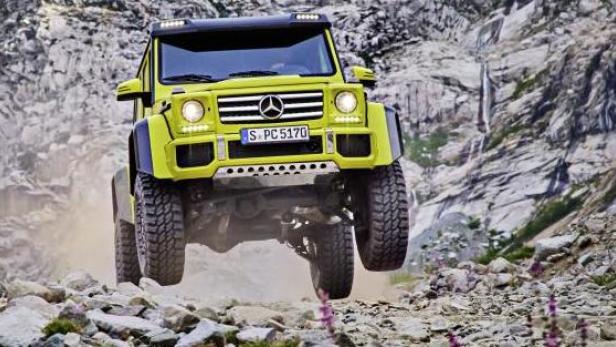 Ein gelber Mercedes-Benz G 500 4x4² fährt über eine steinige Bergstrecke.