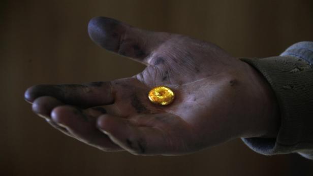 A small-scale miner holds his gold that was melted together at a processing plant located around 100km (62 miles) north of the Mongolian capital city Ulan Bator in this April 5, 2012 file photo. Mongolia is home to some of the world&#039;s biggest unexploited mineral deposits, and has become one of the hottest destinations for billions of dollars of mining investment, a scale which has already transformed the economy. To match story MONGOLIA-ELECTION/MINING REUTERS/David Gray/Files (MONGOLIA - Tags: ENVIRONMENT BUSINESS EMPLOYMENT SOCIETY COMMODITIES)