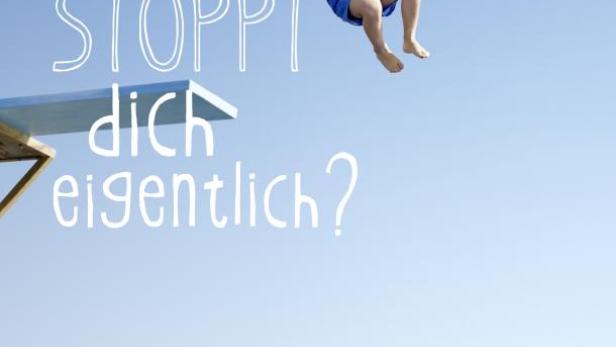 Ein Junge mit Schwimmflügeln springt von einem Sprungbrett ins Wasser.