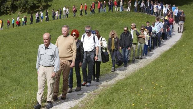 Eine lange Schlange von Wanderern geht einen Pfad entlang.