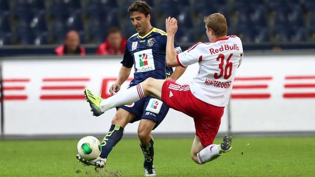 Zwei Fußballspieler kämpfen um den Ball während eines Spiels.