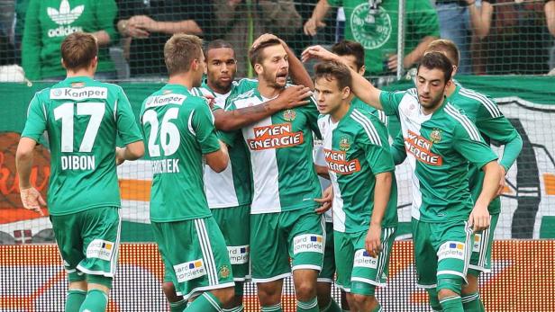 Fußballspieler von Rapid Wien feiern gemeinsam auf dem Platz.