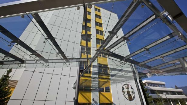 Ein modernes Gebäude mit einer Glasüberdachung vor blauem Himmel.