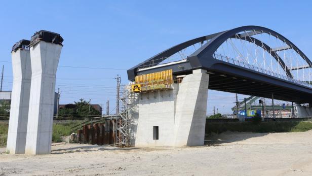 Eine im Bau befindliche Bogenbrücke aus Stahl und Beton.