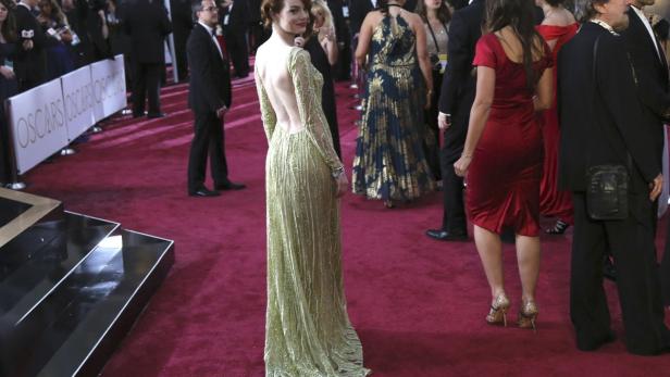 Feierlich: Emma Stone darf nicht nur für ihre Nebenrolle in &quot;Birdman&quot; einen Oscar mitnehmen, sondern auch für ihr Outfit. Für ihren Auftritt am roten Teppich wählte sie eine glamouröse Gold-Limetten-Robe mit aufregendem Rückendekolletée von Elie Saab. Dazu Schmuck von Tiffany &amp; Co..