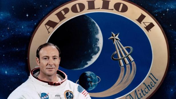 Astronaut Edgar Mitchell vor dem Abzeichen der Apollo-14-Mission.