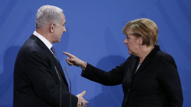 German Chancellor Angela Merkel gestures during a news conference with Israeli Prime Minister Benjamin Netanyahu (L) after bilateral talks at the Chancellery in Berlin December 6, 2012. Merkel and Netanyahu agreed to disagree on the question of Israeli plans to build more Jewish settlements, the chancellor said on Thursday. REUTERS/Thomas Peter (GERMANY - Tags: POLITICS)