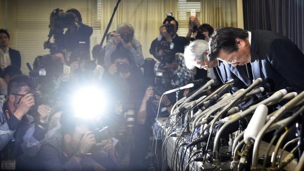 Mitsubishi-Präsident Tetsuro Aikawa (r.) verbeugt sich bei der Pressekonferenz.