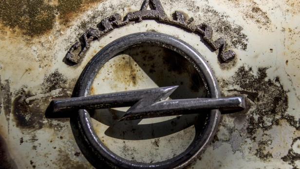 Das verwitterte Opel-Logo auf einem Oldtimer.