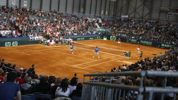 Tennismatch auf einem Sandplatz vor großem Publikum.