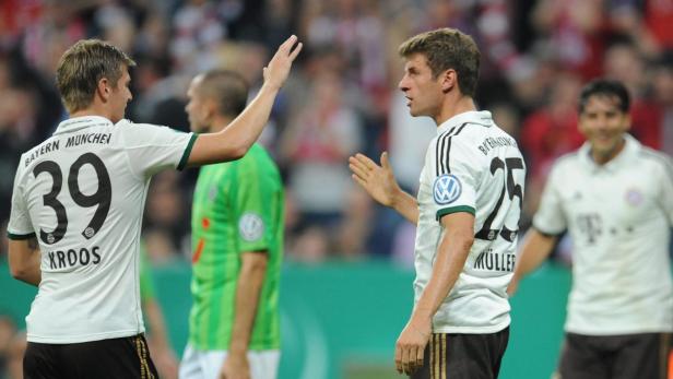 Die Fußballspieler Toni Kroos und Thomas Müller geben sich ein High-Five.