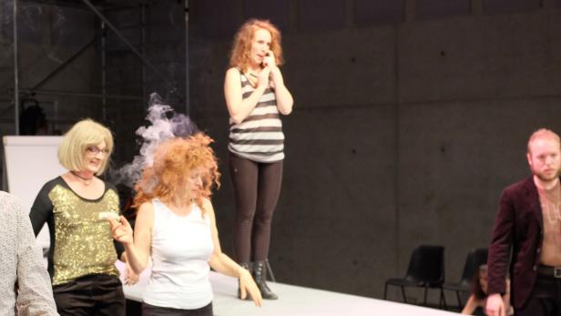 Eine Theaterszene mit mehreren Schauspielern auf einer Bühne.