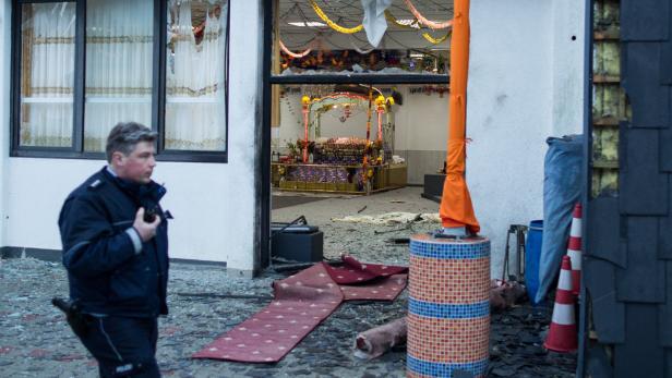 Ein Polizist steht vor einem beschädigten Sikh-Tempel.