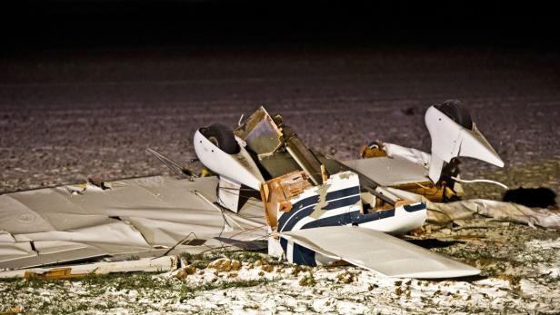 epa03501909 The wreckage of an ultralight aircraft is seen in a field after its collision with a small plane, seen in the back, illuminated by spotlights, in Wolfersheim, Hesse, Germany, 08 December 2012. Seven dead were recovered from both planes. EPA/Nicolas Armer