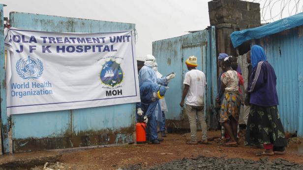 Vor einem Ebola-Behandlungszentrum des JFK-Krankenhauses stehen Menschen und medizinisches Personal.