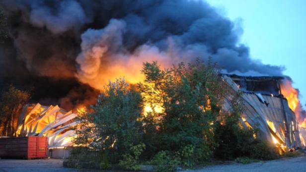 Ein großes Gebäude steht in Flammen, dichter Rauch steigt auf.