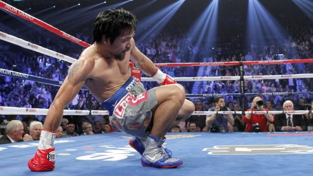 Manny Pacquiao of the Philippines rises from the canvas after being knocked down by Juan Manuel Marquez of Mexico in the third round of their welterweight fight at the MGM Grand Garden Arena in Las Vegas, Nevada December 8, 2012. REUTERS/Steve Marcus (UNITED STATES - Tags: SPORT BOXING)