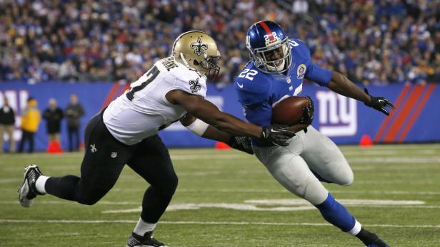 New York Giants&#039; running back David Wilson (R) runs past New Orleans Saints defender David Hawthorne deep in Saints territory in the third quarter in their NFL football game in East Rutherford, New Jersey, December 9, 2012. REUTERS/Mike Segar (UNITED STATES - Tags: SPORT FOOTBALL)