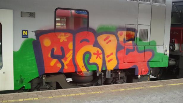 Ein Zug ist mit Graffiti bemalt.
