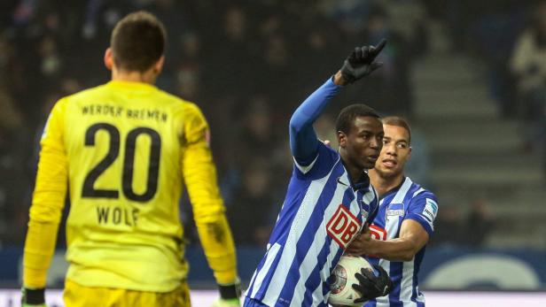 Ein Hertha BSC-Spieler jubelt mit erhobenem Zeigefinger, während ein Mitspieler und der Werder Bremen-Torwart im Bild sind.
