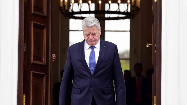 Joachim Gauck verlässt ein Gebäude mit gesenktem Kopf.