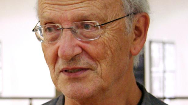 Ein älterer Mann mit Brille schaut aufmerksam in die Ferne.