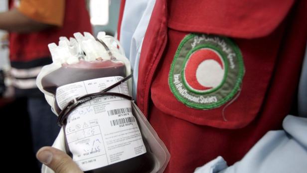 Ein Blutbeutel wird neben der Uniform des irakischen Roten Halbmonds gehalten.