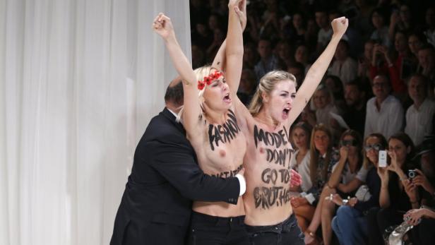Activists of Ukrainian women's rights group Femen Bereits am dritten Tag wurde die Pariser Fashion Week gestürmt: Zwei Femen schafften es bei der Show von Nina Ricci auf den Catwalk und mussten von Bodyguards entfernt werden.