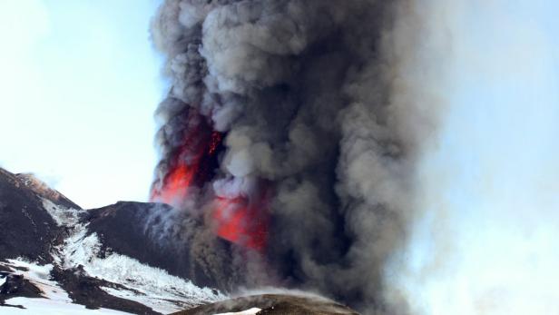 Ein Vulkan bricht aus und speit Rauch und Lava in den Himmel.