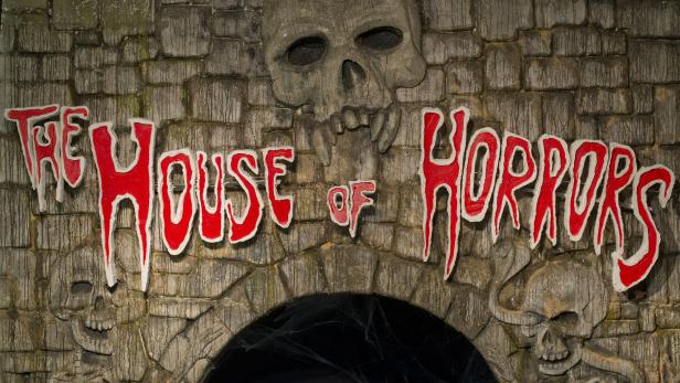 Die Fassade des „The House of Horrors“ mit Totenköpfen und roter Schrift.