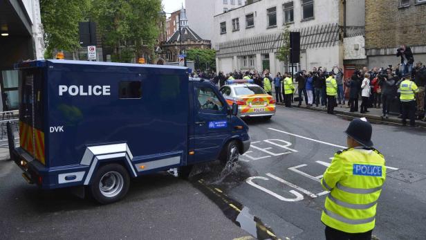 Ein Gefangenentransporter der Polizei fährt durch eine Wasserpfütze.