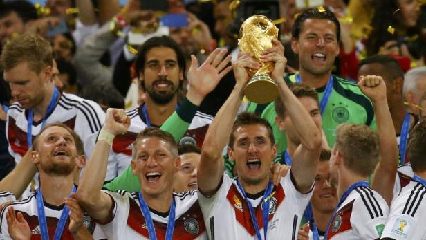 Die deutsche Nationalmannschaft feiert mit der FIFA-Weltmeisterschaft-Trophäe.