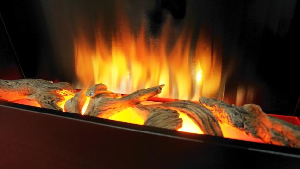 Ein elektrischer Kamin mit glühenden Holzscheiten und simulierten Flammen.