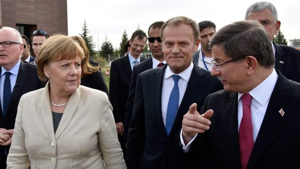 Angela Merkel und Donald Tusk treffen sich mit einer Gruppe von Personen.