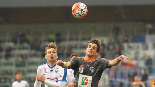 Zwei Fußballspieler kämpfen um einen Ball in der Luft.