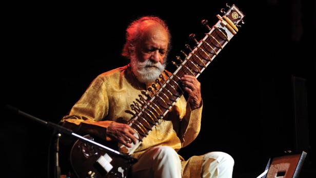 INDIA MUSIC Ein älterer Mann mit Bart spielt auf einer Sitar.