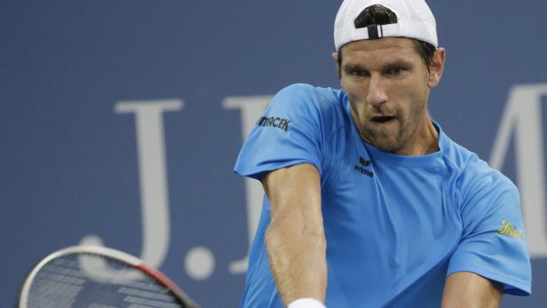 Ein Tennisspieler bei einem Aufschlag während eines Spiels.