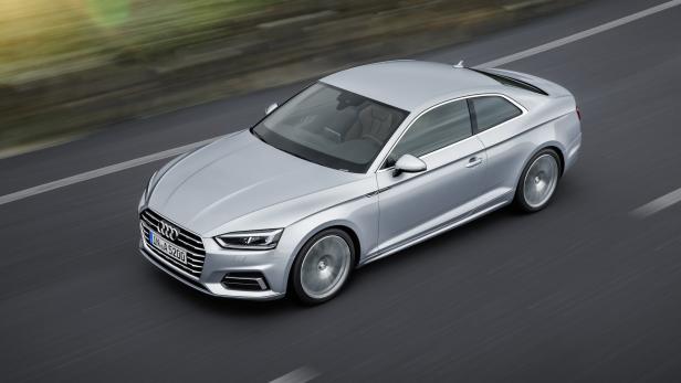 Ein silberner Audi A5 fährt auf einer asphaltierten Straße.