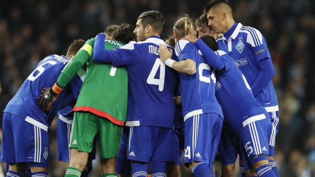 Eine Gruppe von Fußballspielern umarmt sich auf dem Spielfeld.