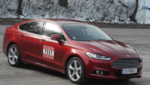 Ein roter Ford steht vor einer winterlichen Landschaft.
